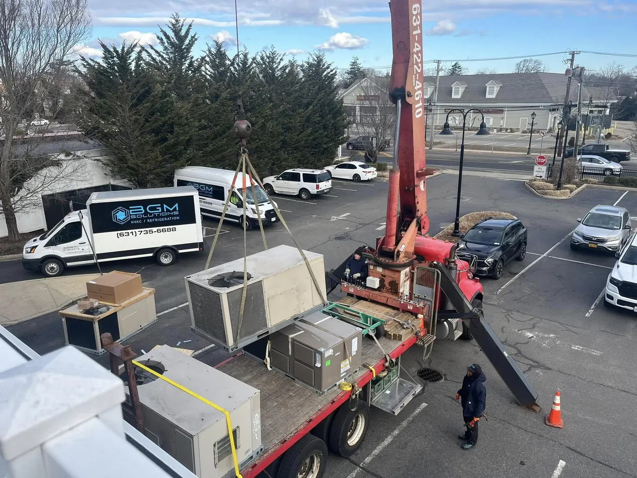 Crane setting new rooftop equipment during a BGM installation